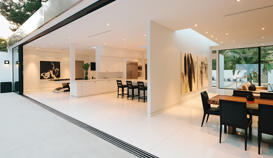 Multi-track glass doors by Fleet­wood slide away, removing any ­barrier between the interior spaces and the courtyard.