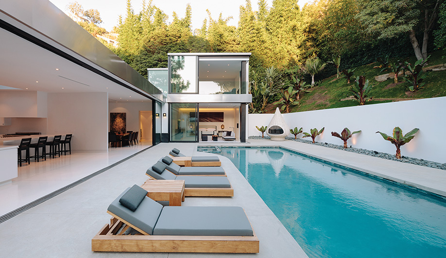 At the centre of the house, a boot-shaped pool with a row of loungers by Marmol Radziner invites relaxation.  