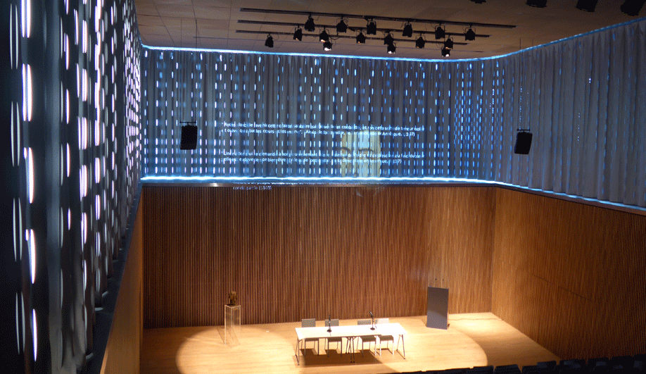 Two layers of curtains surround the auditorium inside Bibliothèque Alexis de Tocqueville in France. The building, by OMA, was completed earlier this year. 