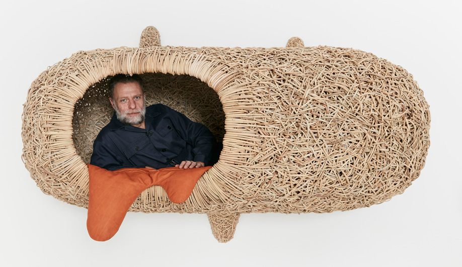 Porky Hefer reclines in one of his wall-mounted, human-size “nests” woven from kubu cane.